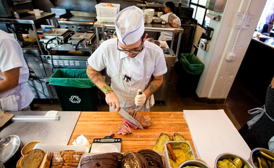 Tyler Sundet, a co-owner of Mamaleh's, carves up some corned beef.