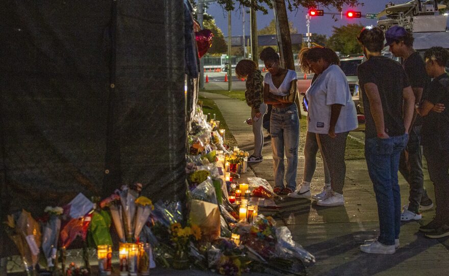 People attend a makeshift memorial on Sunday at the NRG Park grounds where eight people died in a crowd surge at the Astroworld Festival in Houston.