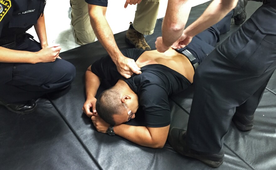 Police trainers place bandages on Officer Edgar Gonzalez's back after removing Taser prongs. He was Tased as part of his training at Norwalk Police Department's headquarters in Norwalk, Conn.