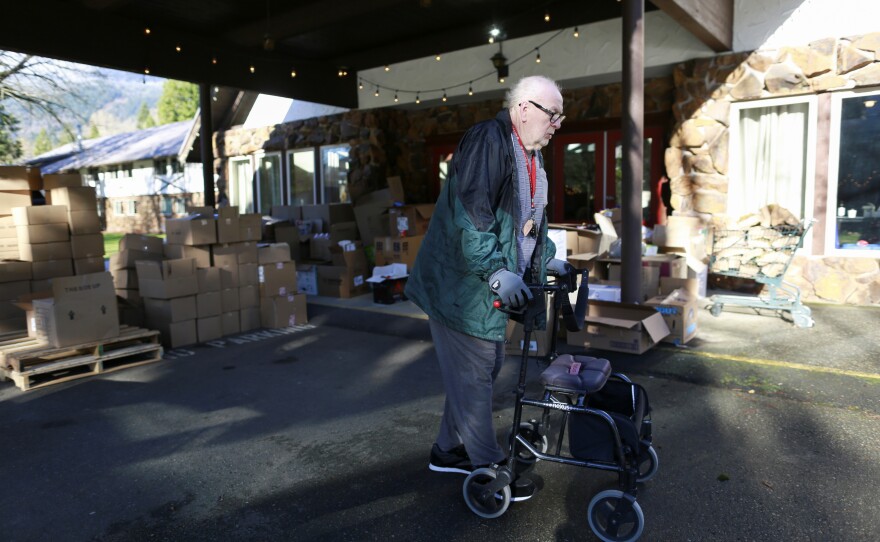 David Crozier walks past piles of donated supplies at Camp Hope after rainstorms caused flooding and landslides that cut off highways across British Columbia, in Hope, Canada Nov. 19. Crozier and his wife Doreen have lived at Camp Hope for months since fleeing wildfires that destroyed the town of Lytton, British Columbia.