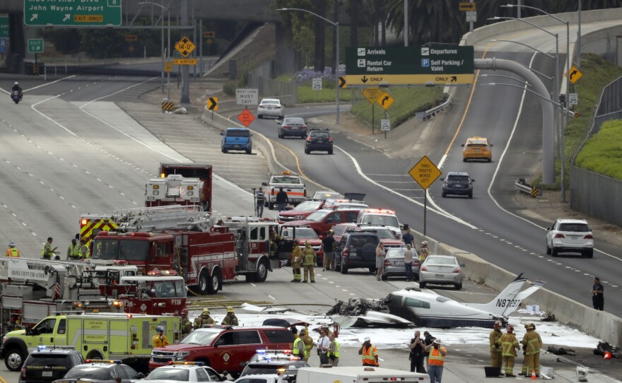 Emergency responders gather round the crash of a Cessna 310 aircraft on Interstate 405, just short of a runway at John Wayne Airport in Costa Mesa, Calif Friday, June 30, 2017.