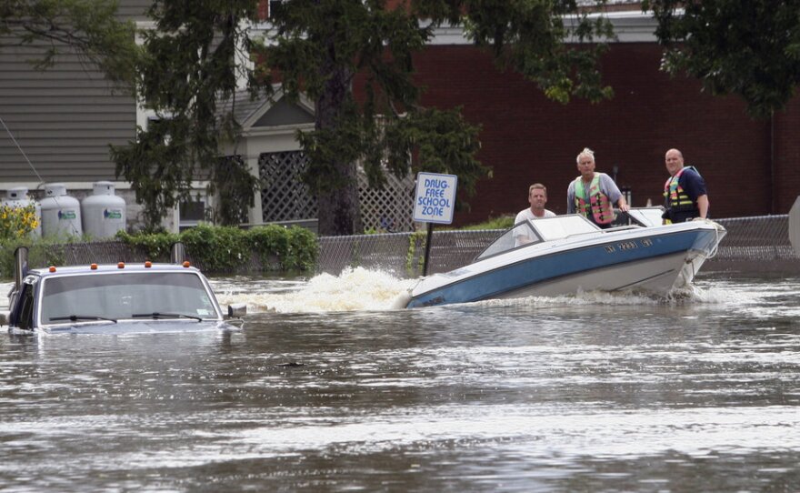 A motorboat passes a submerged pickup truck on Main Street in Washingtonville, N.Y., on Sunday following heavy rains from Tropical Storm Irene.