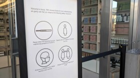 A sign in front of the Aesop store in Fashion Valley Mall advising people to socially distance and wear a mask in the store, Nov. 28, 2020.