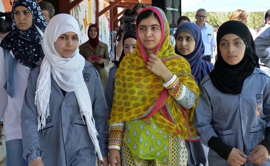 Malala Yousafzai walks with Syrian refugees on her 18th birthday, during the opening of a school for refugee girls in Lebanon's Bekaa Valley.