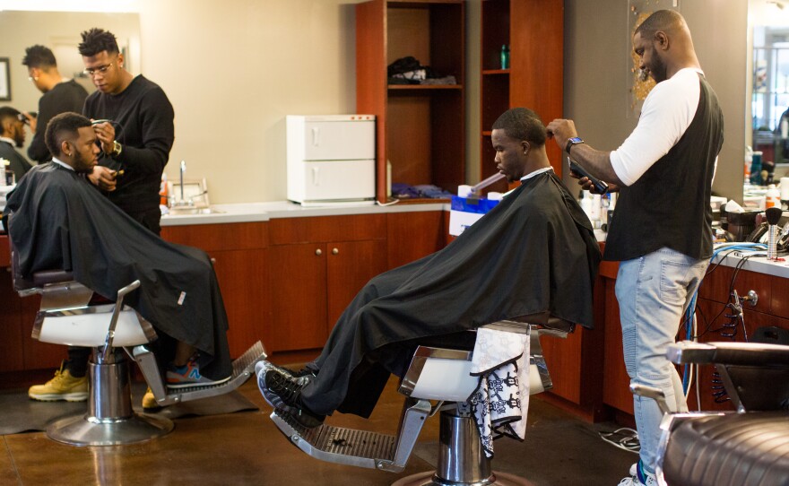 Customers get haircuts on a busy Saturday morning at No Grease Mosaic Village in Charlotte, N.C.