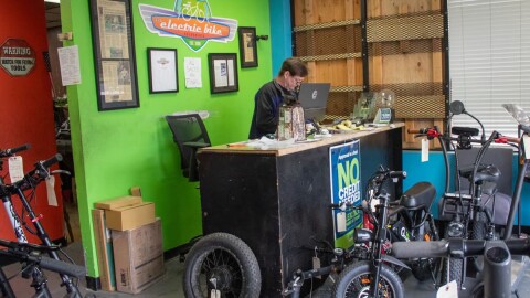 The Electric Bike Shop owner Mike Majors stands behind his desk Monday, Nov. 17, 2025, at 5704 Broadway in Sacramento.