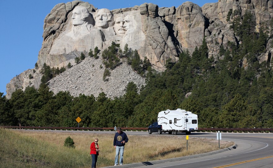 Tourists stop on the roadside near Mount Rushmore, after their visit was canceled due to the government shutdown. South Dakota and other states have reached an agreement to fund operations to reopen the parks.