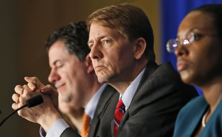 Consumer Financial Protection Bureau Director Richard Cordray, center, listens to comments during a field hearing on payday lending in Richmond, Va., in May.