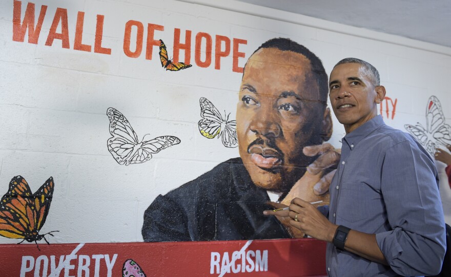 Then-President Barack Obama helps paint a mural of Martin Luther King Jr. in 2017.