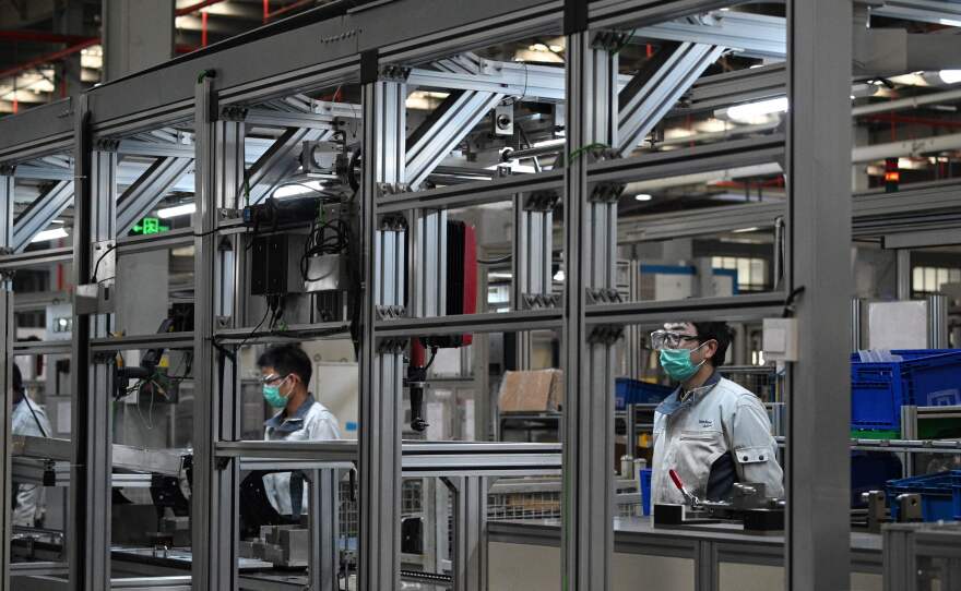 Workers wear protective face masks at the Yanfeng Adient factory in Shanghai, where car seats are assembled, on Feb. 24.