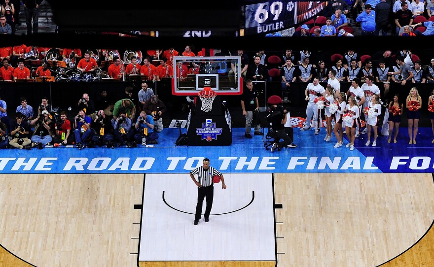 An official and others wait for play to resume between the Butler Bulldogs and the Virginia Cavaliers during a second-round NCAA men's tournament game in March in Raleigh, N.C. This coming spring, the road to the Final Four won't go through North Carolina, as the NCAA has decided to move three games out of Greensboro.