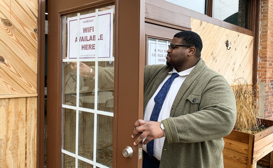 Anthony Hill, Fair Count's communications associate, posts signs encouraging people to use the free Wi-Fi and apply for 2020 census jobs at ARC Community Center in Fort Gaines, Ga.