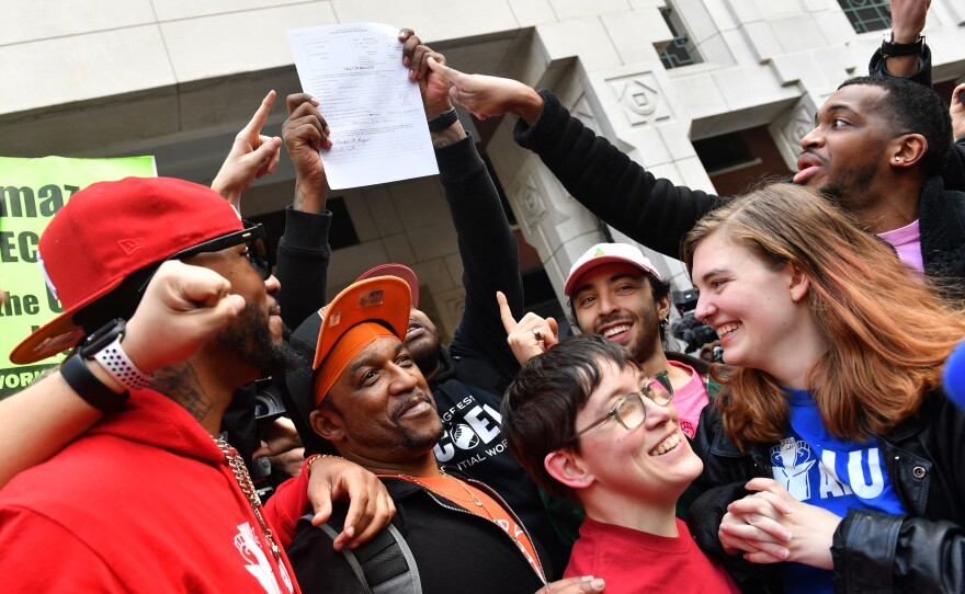 Amazon Labor Union president Chris Smalls (left) celebrates with Amazon workers following the April 1, 2022, tally of votes in the union election at an Amazon warehouse on Staten Island in New York.