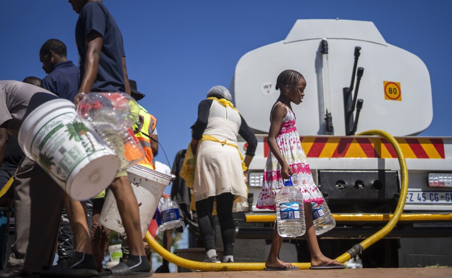 Residents of the township of Soweto, South Africa, try to get water on March 16.