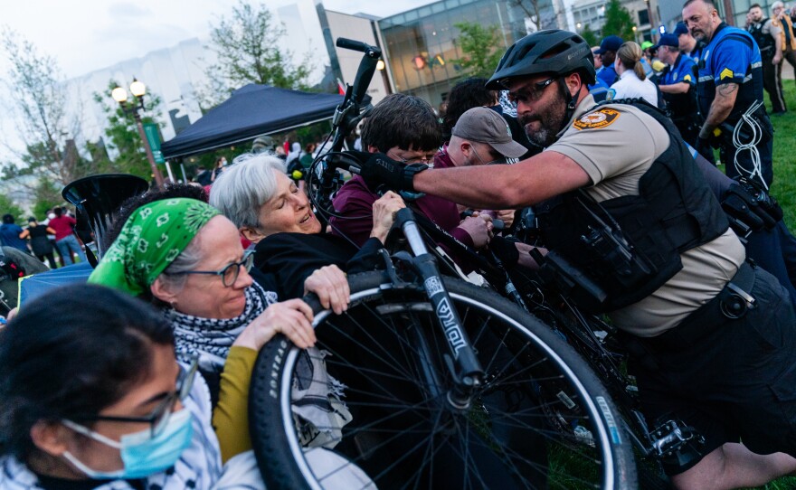 A St. Louis County police officers rams a bicycle into presidential candidate Jill Stein and other pro-Palestine demonstrators during a rally on April 27, at Washington University.