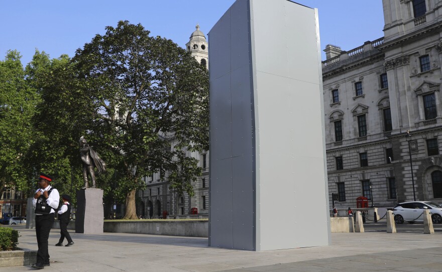 Westminster Council street marshals stand next to a protective covering installed overnight surrounds the statue of former British Prime Minister Sir Winston Churchill in Parliament Square, London, following Black Lives Matter protests that took place across the UK over the weekend.