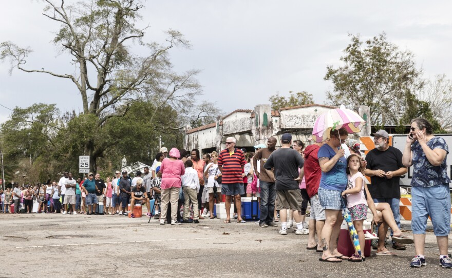 People wait in line for ice in Wilmington, N.C., on Monday.