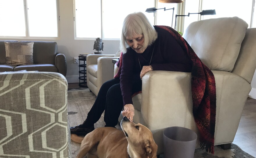 Ginny talks to Kelly’s dog Willow , whose familiar spot the foot of her chair, Feb. 11, 2019.