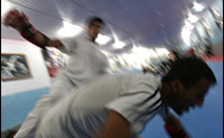 Bahawe slams a teammate to the mat with a roundhouse kick to the side during a sparring match. Bahawe won a silver medal at the 2007 tae kwon do world championships.