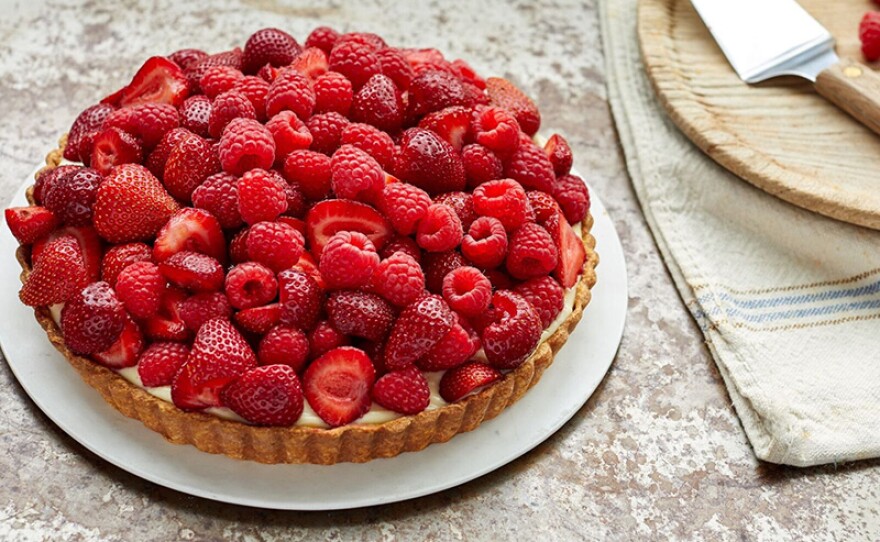 A red fruit tart piled high with colorful berries. 