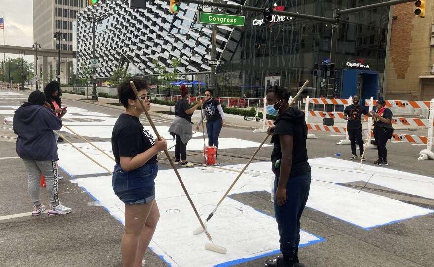 A mural displaying the words "Power To The People" is repainted in honor of Juneteenth by students studying at the University Prep Art Design. The mural was first painted last year for the holiday.