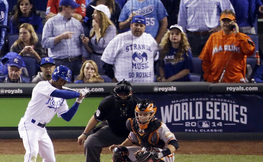 Miami Marlins fan Laurence Leavy, rear right, is shown wearing a bright orange Marlins jersey Oct. 22 during a playoff game in Kansas City. Leavy's orange Marlins jersey made him easy to spot amid a sea of Kansas City Royals blue. He said that a Royals official approached him offering to move him to the team owner's suite, but that he declined.