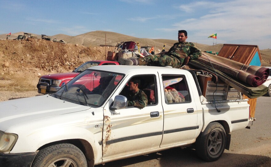 Trucks loaded with household appliances line up on their way out of Sinjar city. Iraqi Kurdish soldiers said they tried to stop people from leaving with suspected looted goods. But soon, the trucks outnumbered the soldiers and they let them through.