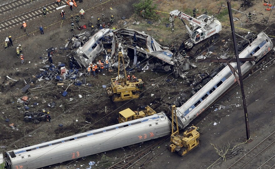 Emergency personnel work at the scene the day after a deadly train derailment on May 12 in Philadelphia.