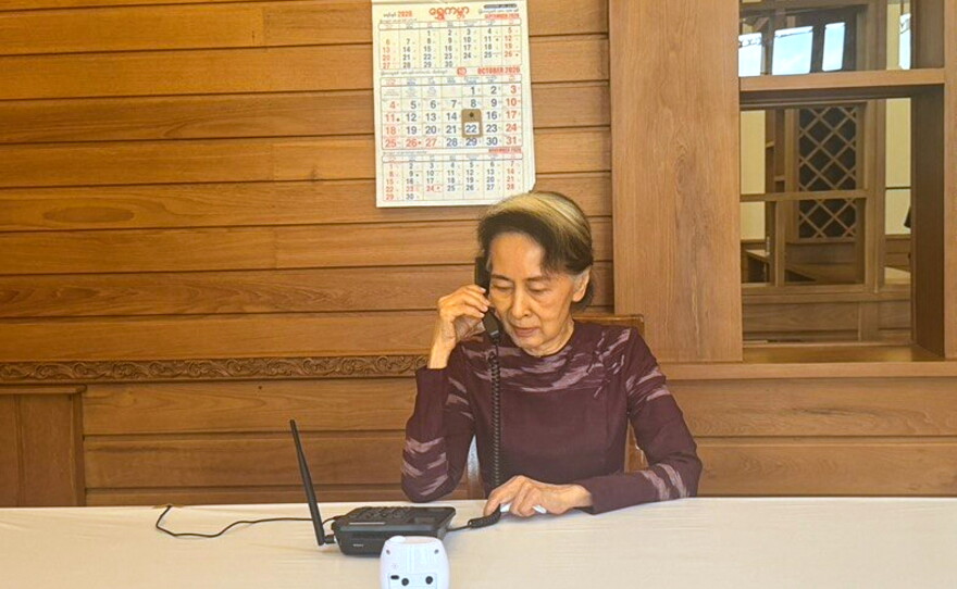 In this photo released by Myanmar's government on Thursday, Myanmar's ousted leader Aung San Suu Kyi talks on the phone with her son Kim Aris, in Naypyidaw, Myanmar.