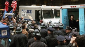 A protester affiliated with Occupy Wall Street sits in a police vehicle after being arrested a few blocks away from the New York Stock Exchange on November 17, 2011 in New York City. 