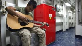 Corporal Bernard Vu, field radio operator, 2nd Platoon, Battery B, Battalion Landing Team 3/5, 15th Marine Expeditionary Unit, practices playing guitar aboard USS Rushmore, Feb. 27.
