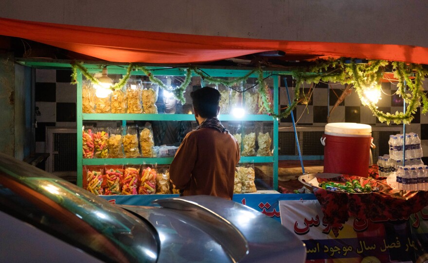A man buys snacks from a street vendor in Kabul in July.