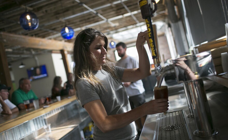 Molly Mattin pours beer at Mother Stewart's Brewing in Springfield. The new brewery, located in an old warehouse space, is part of the city's downtown revival that includes new shops and a farmers market.
