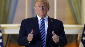President Donald Trump stands on the balcony outside of the Blue Room as returns to the White House Monday, Oct. 5, 2020, in Washington, after leaving Walter Reed National Military Medical Center, in Bethesda, Md. Trump announced he tested positive for COVID-19 on Oct. 2. 