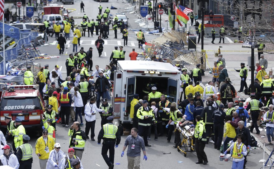 First responders aid injured people at the finish line of the Boston Marathon after the bombing on April 15.