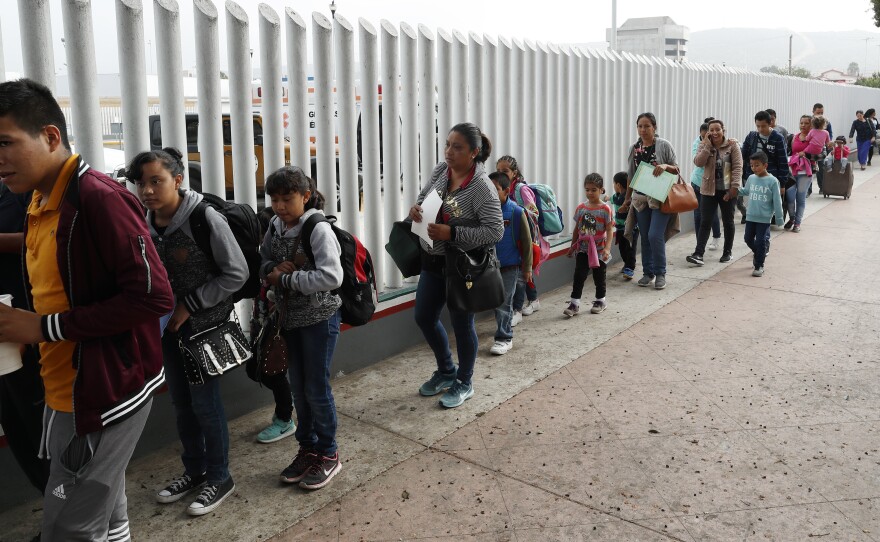People line up to cross into the United States to begin the process of applying for asylum near the San Ysidro Port of Entry in Tijuana, Mexico. President Trump has threatened to close the border to asylum-seekers.