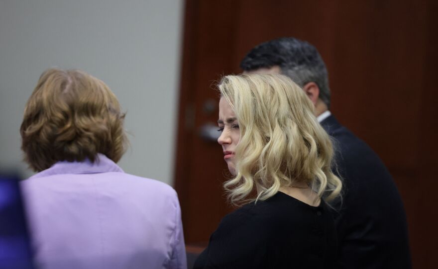 Actor Amber Heard looks at her lawyer before the jury said that they believe she defamed ex-husband Johnny Depp.