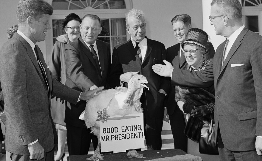 President John F. Kennedy reaches out to touch a 40-pound turkey at the White House in 1963. The presentation was made on behalf of the nation's turkey industry.