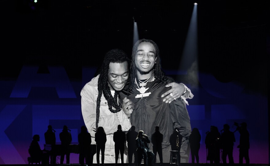 Quavo (center, seated) performs while an image of him and the late Takeoff is projected on a screen during the 65th GRAMMY Awards.