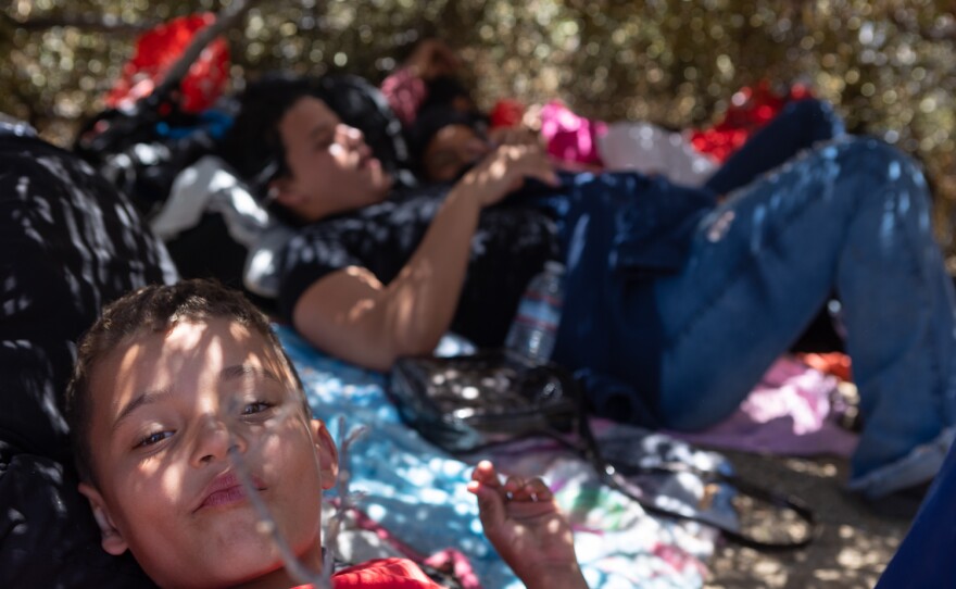 A group of migrants from Brazil rest under the shade of a makeshift shelter in the Jacumba Wilderness on May 12, 2023. Hundreds have been in the area for days with little food and water and no shelter while waiting to be processed by Customs and Border Patrol.