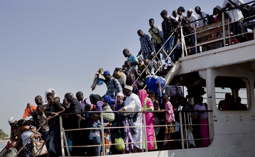 A ferry carrying people who fled Gambia arrives at the port in Banjul, Gambia, on Sunday.