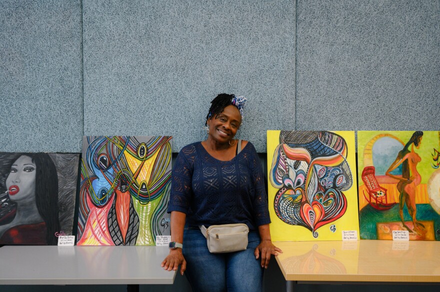 Artist Breezie Bennett stands for a portrait between four of her paintings during a Juneteenth celebration of Black art organized by Liberation Through Art and the San Diego Art Directory at the Chula Vista Public Library in Otay Ranch on June 21, 2024.