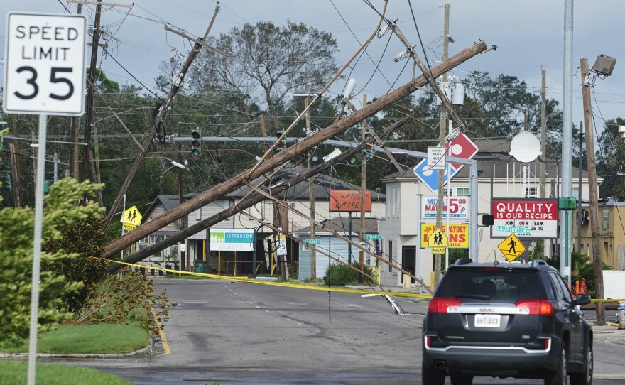 Traffic diverts around downed power lines Monday, Aug. 30, 2021, in Metairie, La. The one-two punch of pandemic and natural disaster is complicating efforts to evacuate hospitals, seek shelter and administer COVID-19 vaccines.