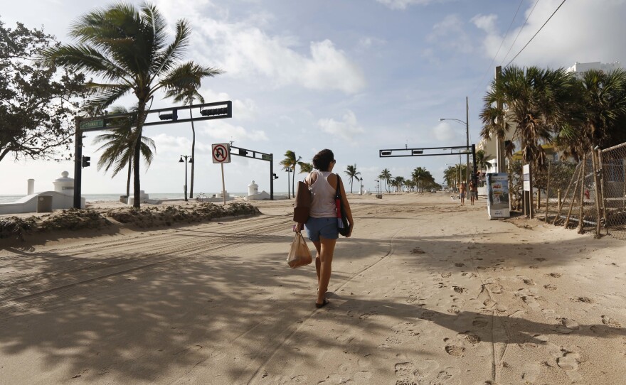 Hurricane Irma dumped water on towns and covered oceanside streets with sand in several states. Here, Amela Desanto walks on the sand-covered road along Fort Lauderdale Beach on Monday, as the storm headed inland.