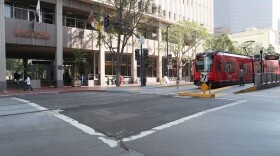The trolley passes in front of the San Diego city administration building. 