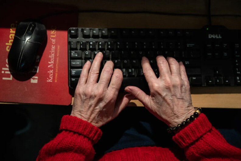 An elderly person types on a keyboard in this undated photo.