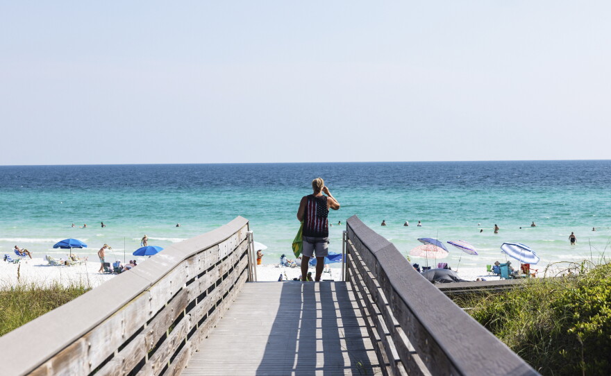 A beachgoer uses the boardwalk at Ed Walline Regional Beach Access off Scenic Highway 30A in Santa Rosa Beach, Fla. This stretch of the Gulf Coast has become "ground zero" in a battle between private property rights and public beach access.