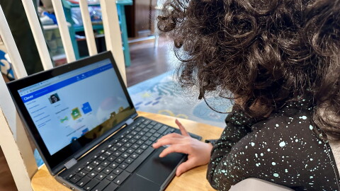 A San Diego Unified School District student works on her school-issued laptop computer to complete an assignment at home in San Diego on May 23, 2023.