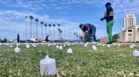 People set up flameless tea lights in San Diego's Watefront Park to honor homeless San Diegans who have died. Oct. 10, 2025.