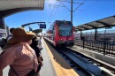 People wait to board the trolley at the Nobel Drive Trolley Station in La Jolla, Calif. Nov. 21, 2021.